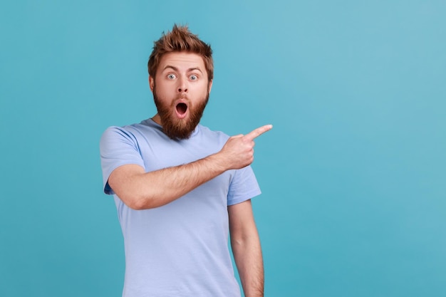 Man in blue Tshirt pointing aside showing blank copy space for idea presentation commercial text