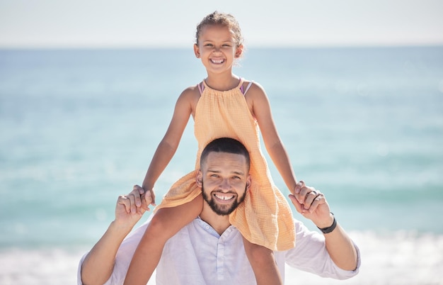 Man bonding and girl in fun beach game on parent shoulders by Spain ocean or sea on summer family holiday Portrait smile and happy father carrying daughter play kid or child in nature environment