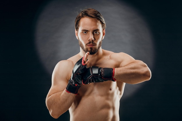 A man in Boxing gloves. A man Boxing on a black background. The concept of a healthy lifestyle.