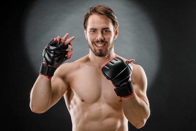 A man in Boxing gloves A man Boxing on a black background The concept of a healthy lifestyle