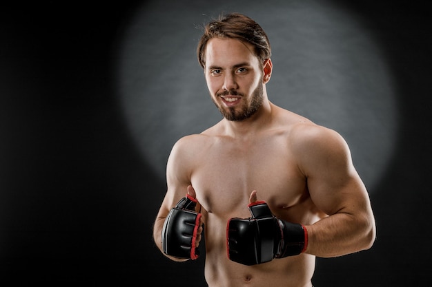 A man in Boxing gloves A man Boxing on a black background The concept of a healthy lifestyle