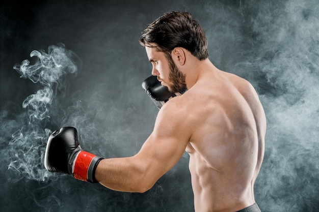 A man in Boxing gloves A man Boxing on a black background The concept of a healthy lifestyle