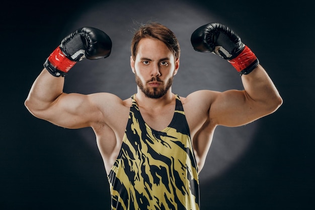 A man in Boxing gloves A man Boxing on a black background The concept of a healthy lifestyle