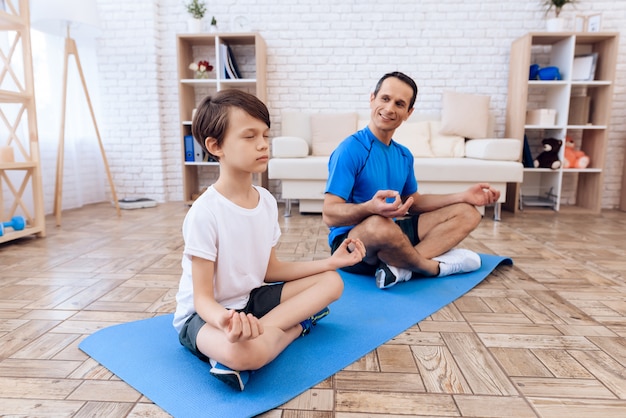 The man and the boy are engaged in yoga.