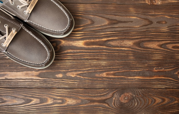 man in brown shoes standing on the wooden background