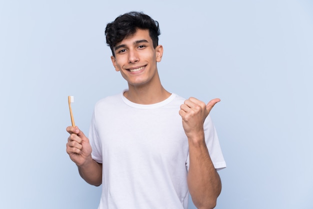 Man brushing his teeth over isolated wall