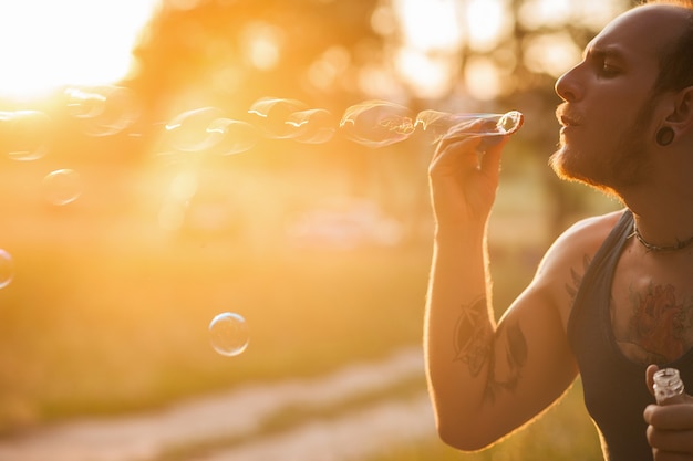 Man bubble blowing portrait nature concept. Unity with the nature. Traveler leisure.