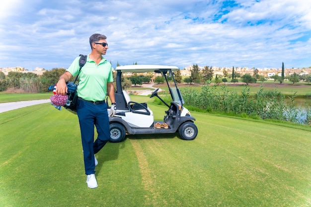 Man in the Buggy with the bag of clubs looking at the course golf club driver iron pitching