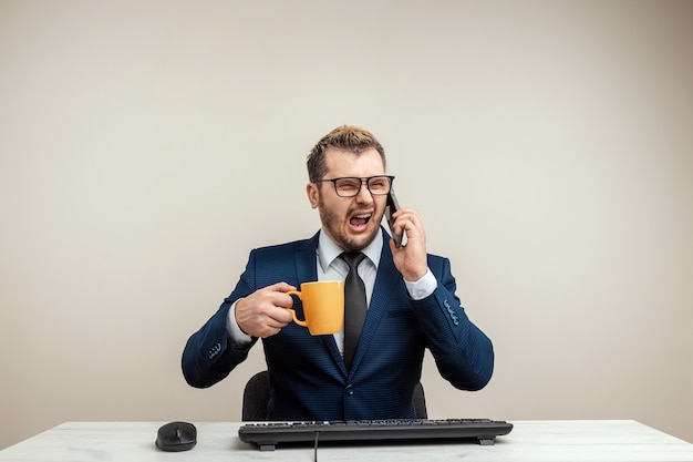 Man businessman is furious and angry at the computer, an office worker is going crazy