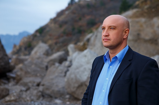 man businessman in a suit standing on the beach