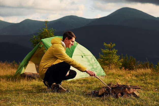 Man busy with making campfire Majestic Carpathian Mountains Beautiful landscape of untouched nature