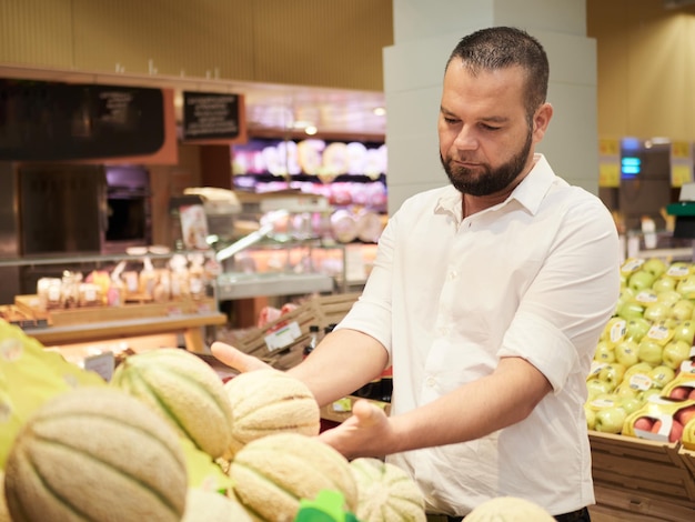 Man buy fruits and vegetables at supermarket