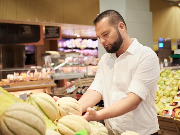 Man buy fruits and vegetables at supermarket