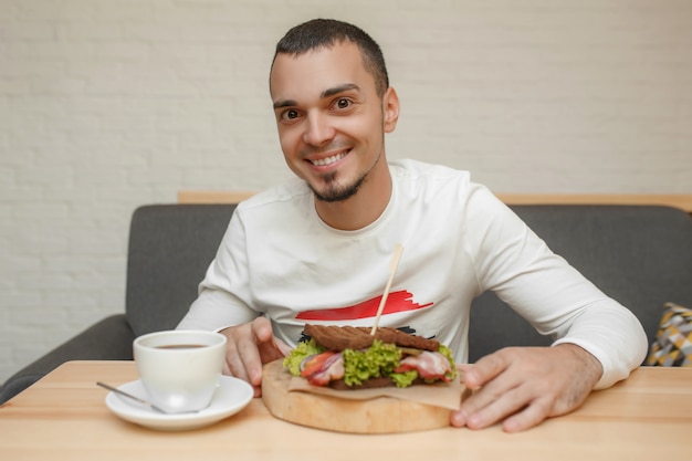 Man in cafe will eat sandwich