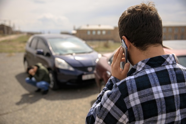 Man calling roadside service after car crash