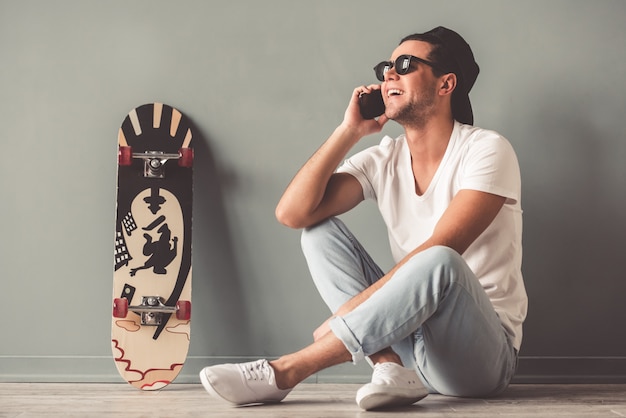 Man in cap and sunglasses is talking on the mobile phone