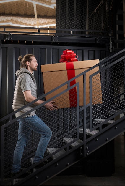 Photo man carrying giant present full shot