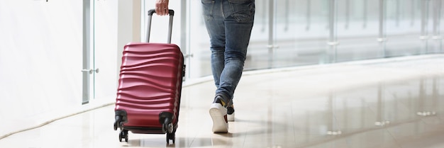 A man carrying a suitcase at the airport terminal