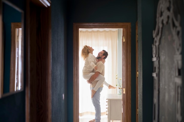 Man carrying woman at home full of happiness and joyful couple enjoy morning wake up indoor Leisure overjoyed activity for adult people in new apartment lifestyle together