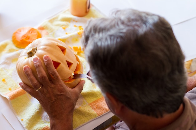 man carving a pumpkin