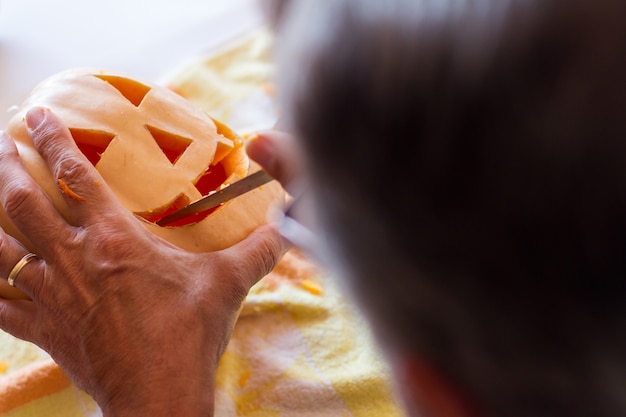 man carving a pumpkin