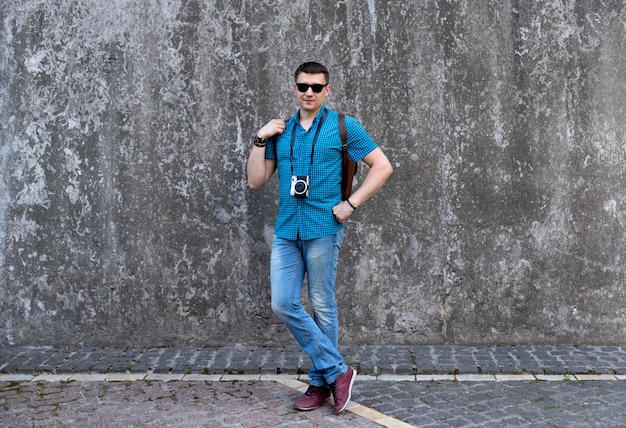 Man in casual clothes with camera and backpack