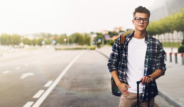 Man catching a taxi in airport with a suitcase