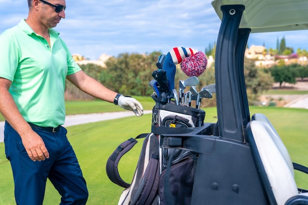 Man caucasian in the Buggy with the bag of clubs playing golf golf club