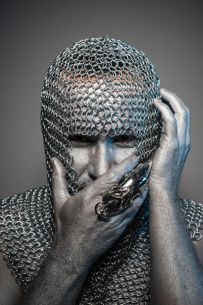 man in chain mail and leather painted silver, medieval warrior