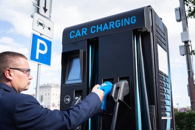 Man charges an electric car at the charging station electric car battery charging station on a city street A modern gas station with electricity