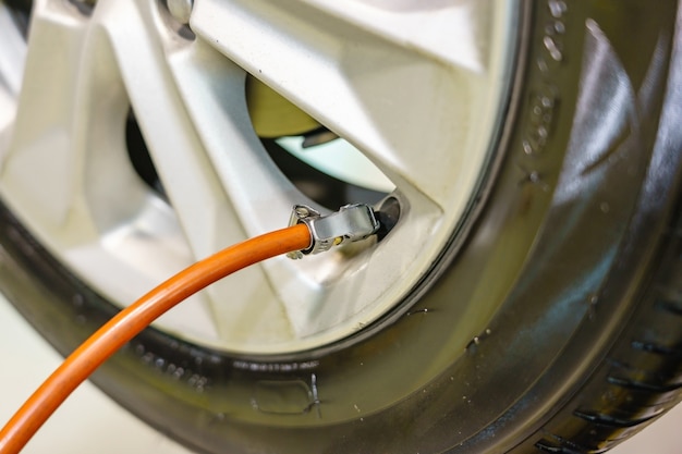 Man checking air pressure and filling air in the tires of his car