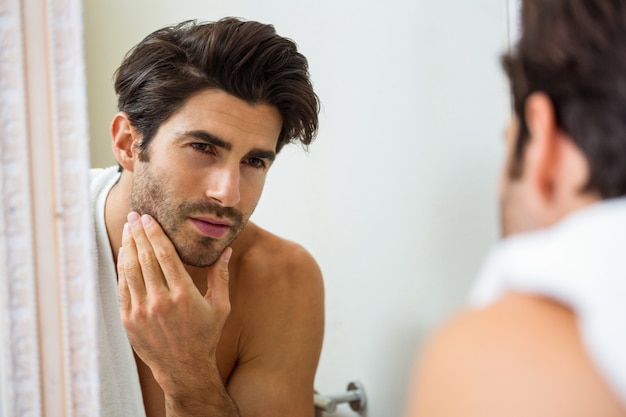 Man checking his stubble in bathroom