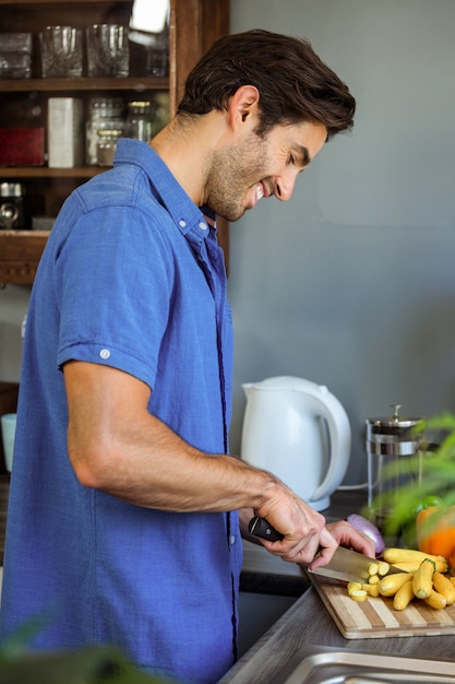 Man chopping vegetables at kitchen counter