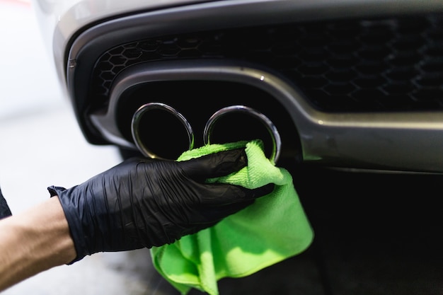 A man cleaning car with microfiber cloth, car detailing (or valeting) concept. Selective focus.