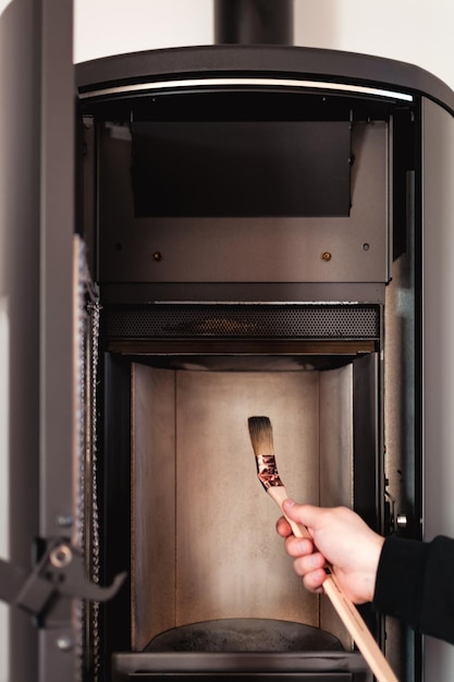 Man cleaning pellet stove with brush