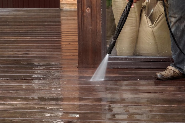 Man cleaning walls and floor with high pressure