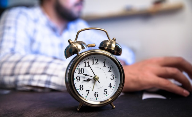 Man and clock on table