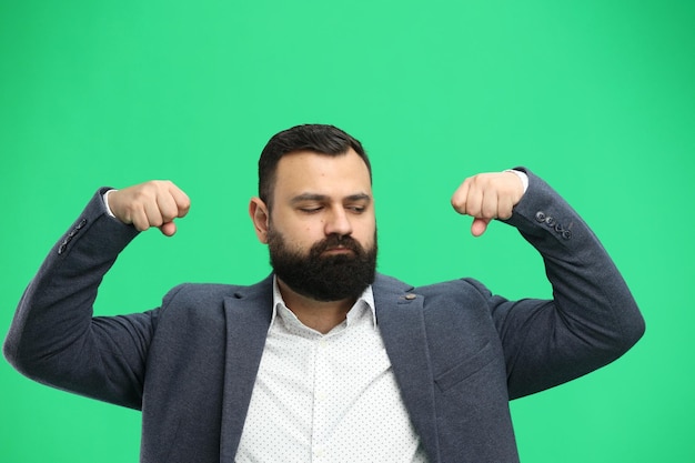 Man closeup on a green background shows strength