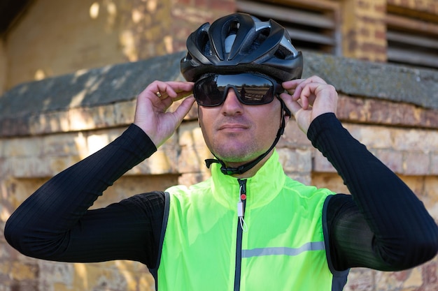 A man in clothes stands with a bicycle on an autumn sunny day Cyclist in an urban environment