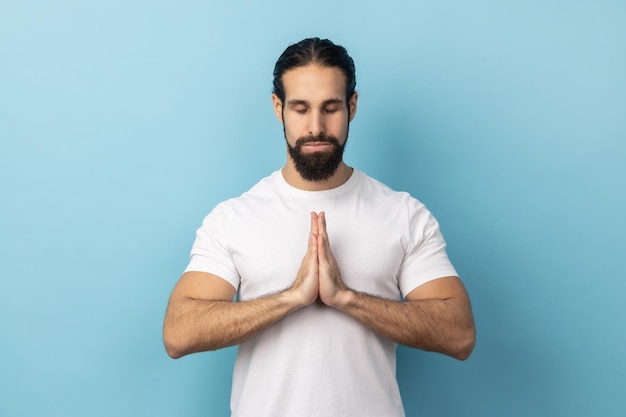 Man concentrating his mind keeping hands namaste gesture meditating yoga exercise breath technique