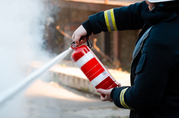 A man conducts exercises with a fire extinguisher. Fire extinguishing concept. Fire emergency incident