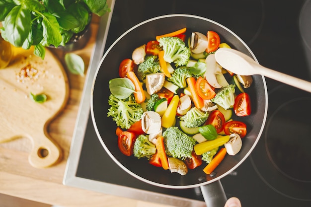 Man cooking fresh vegetables on pan