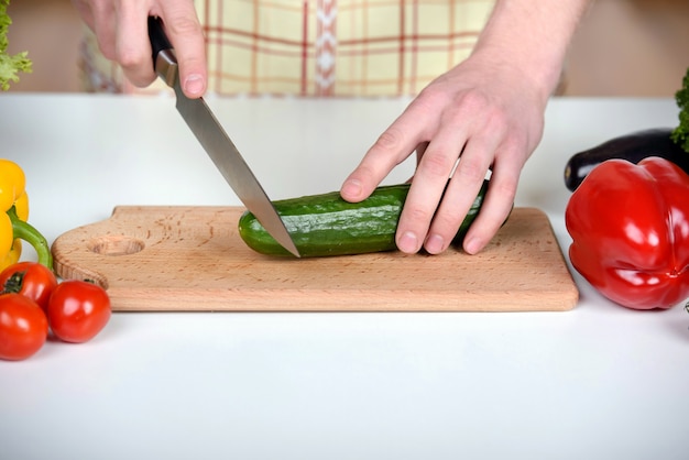 Man cooking at home preparing salad in kitchen.