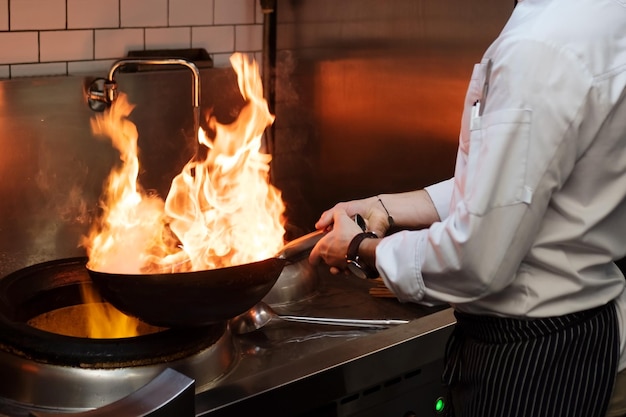 A man cooks cooking deep fryers in a kitchen fire