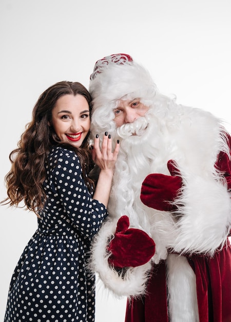 Man in costume of santa claus and beautiful girl on white background Woman with santa claus together Christmas holidays and people concept