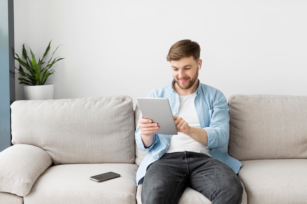 Man on couch using tablet