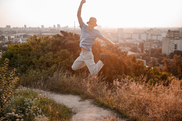 Photo a man on the countryside background jumping and feeling excited