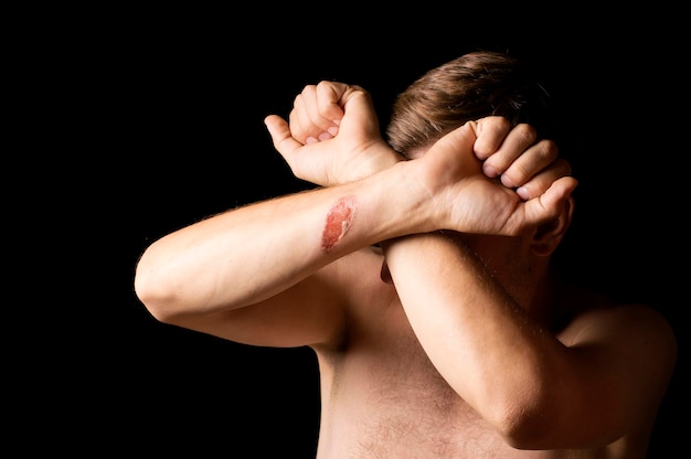 Photo man covers his face with his hands on a black background