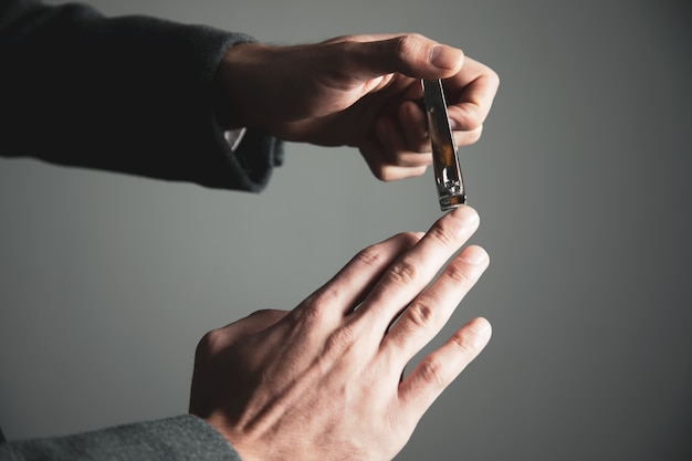 Man cutting fingernails with clipper isolated