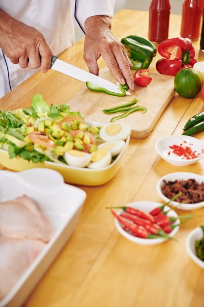 Man cutting green bell pepper f